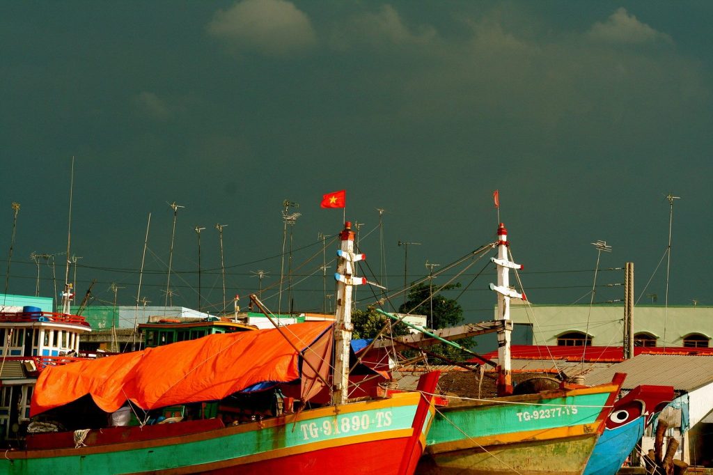 Wooden fishing boats moored on the Hau River at Can Tho as daylight fades