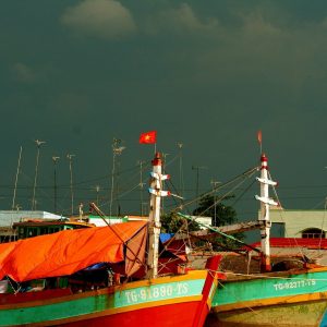 Wooden fishing boats moored on the Hau River at Can Tho as daylight fades
