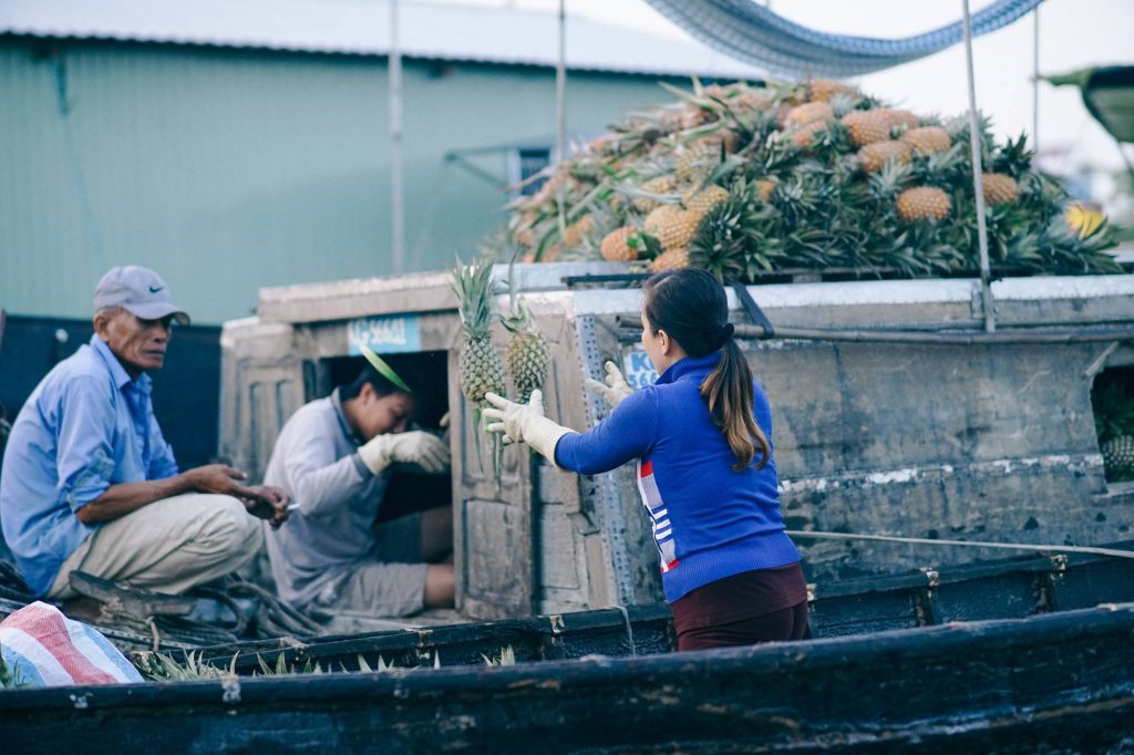 vendors exchanging goods boat to boat — Cai Rang Floating Market at Dawn, mekongtodo real Mekong Delta tour
